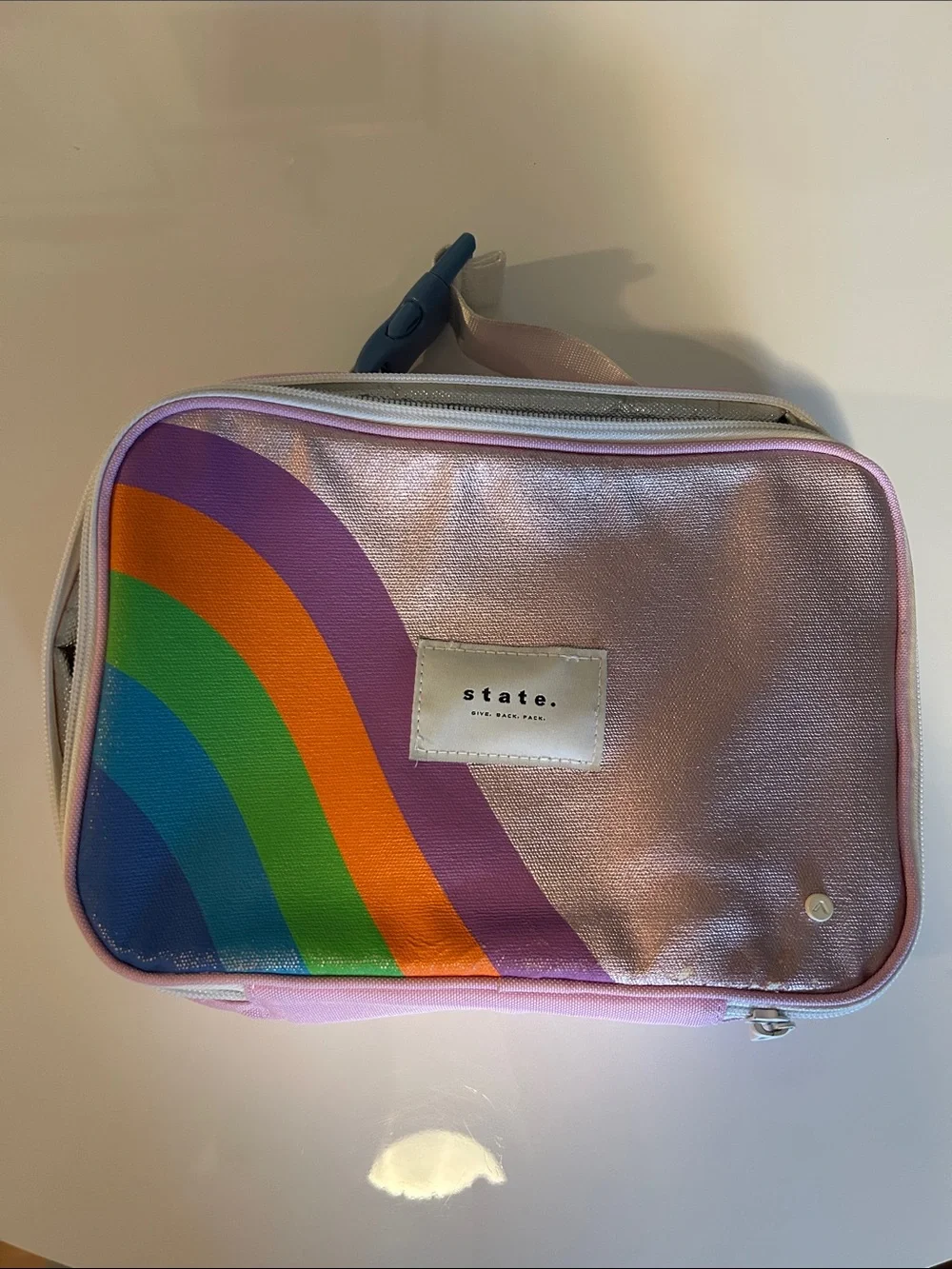 STATE Metallic Pink lunch box with Rainbow Accent with some wear .